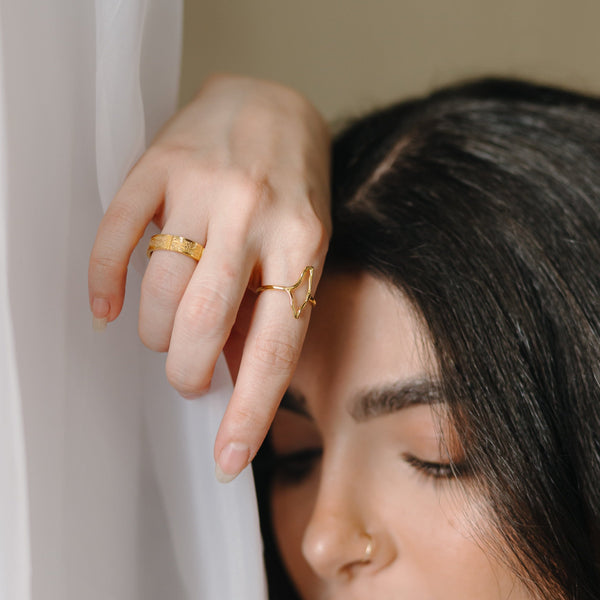 A model wearing the Hometown Ring in gold, with the outline of the map of Palestine sitting prominently atop the finger, forming the main body of the ring.