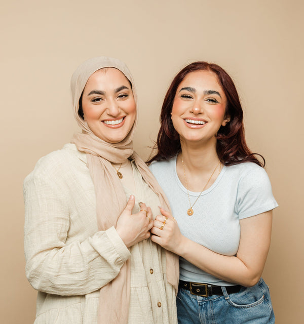 Two models wear one necklace each from the set, with the pendants symbolizing a shared connection and unity in friendship.