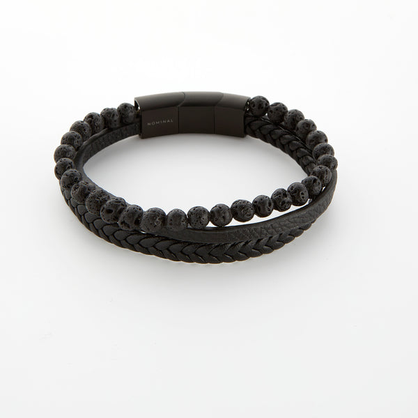 Triple-layered black bracelet with lava rock beads and braided leather strands, featuring a black magnetic clasp engraved with “Nominal.”