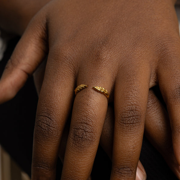 The ring worn on a model's finger, showcasing its elegant fit and the delicate olive leaf design in a real-life context.