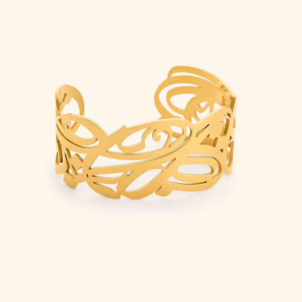 A gold cuff bracelet with intricate, swirling cut-out designs. The bracelet is wide and open-ended, and the delicate patterns create a lacy or filigree effect. The text "GRACE (Cuff) | Aadil x Nominal" indicates this is a product shot of the "Grace" cuff bracelet, a collaboration between Aadil and Nominal.