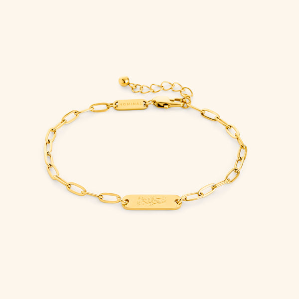 Gold Sakinah Serenity link bracelet showing the Arabic engraving on center tag, photographed against a light background.