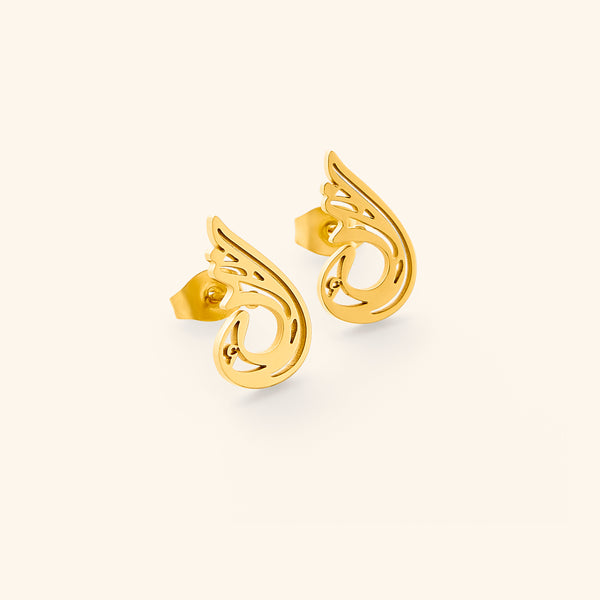 A pair of gold "Serenity Earrings" from the Aadil x Nominal collection. The earrings feature a unique, abstract, teardrop-like design with swirling cut-out details. The metal has a warm gold color. The image is a product shot, likely showcasing the design and craftsmanship of the earrings.