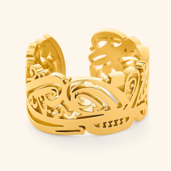 A gold ring with intricate carved cut-out designs, inspired by ancient artistry. The ring features detailed patterns and may have floral or geometric motifs. These rings can be both modern and traditional, with designs ranging from minimalist to ornate.