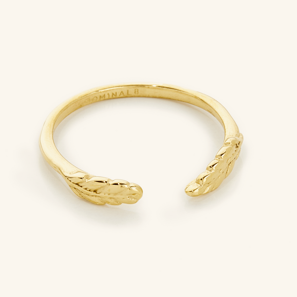 A close-up of the Palestine Olive Leaf Ring V2 in 18K gold plating, featuring an open band design adorned with detailed olive leaves at each end.